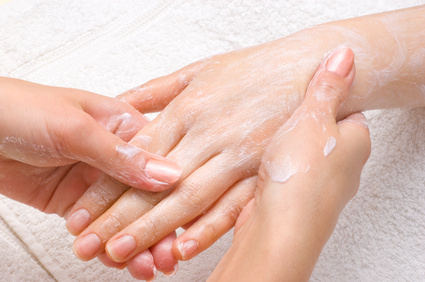 applying peeling scrub or moisturizing cream onto the hands